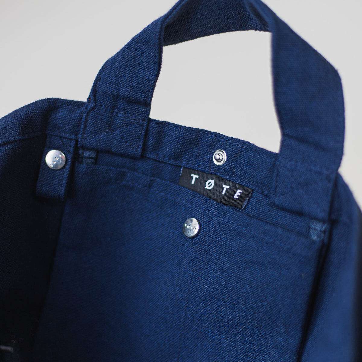 The buttoned inner accessory pocket of the Navy Blue TØTE Bag