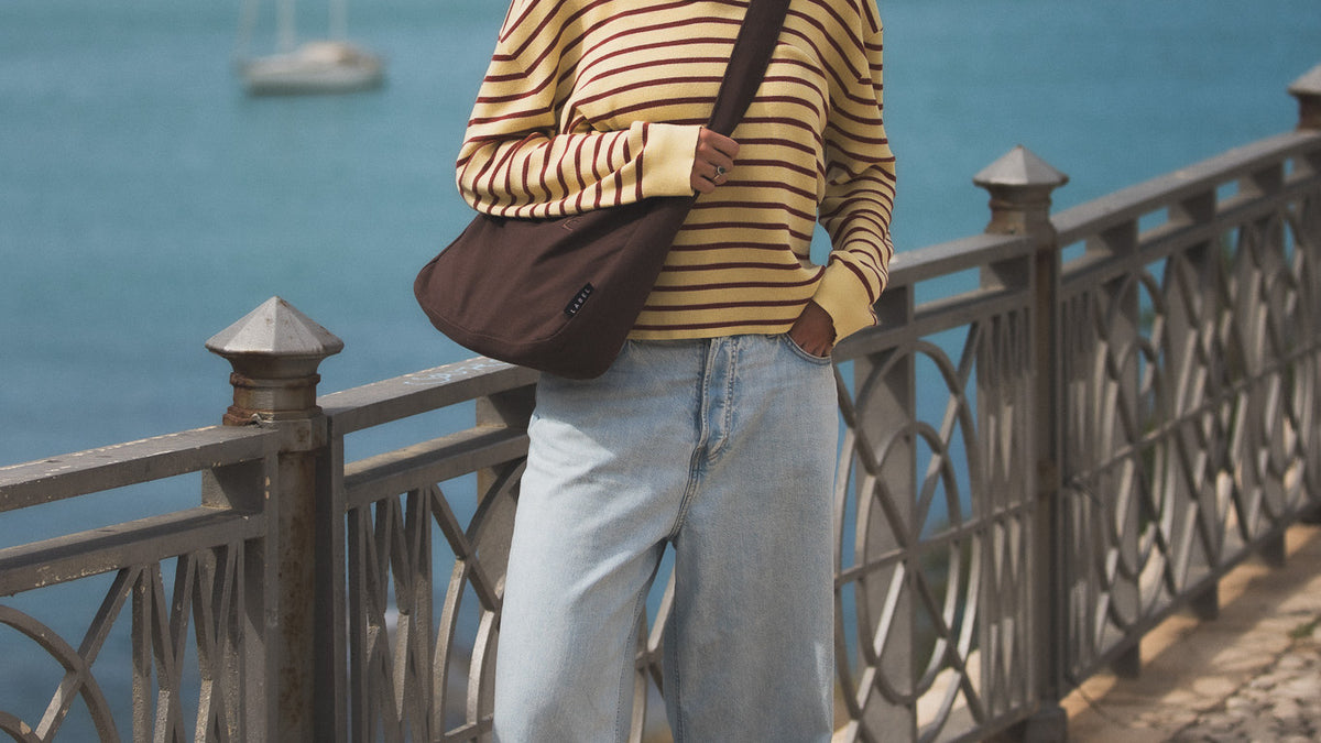 A brown ALTA worn across the body on a seafront promenade in Sicily