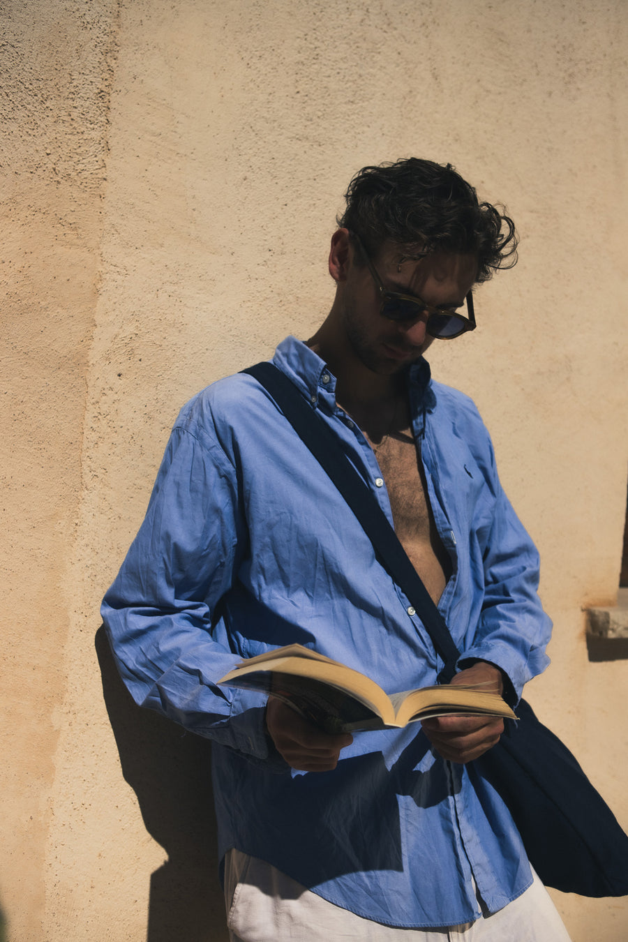 Navy Blue TØTE Bag under the arm while reading in the sun